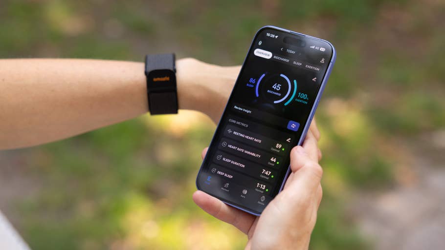Eine Person überprüft Gesundheitsmetriken auf einem Smartphone und trägt ein Amazfit Helio-Armband am Handgelenk.