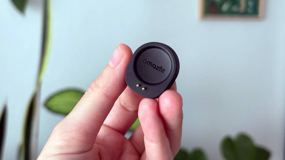 Eine Person hält ein Amazfit Helio-Armbandteil mit einer grünen Pflanze im Hintergrund.