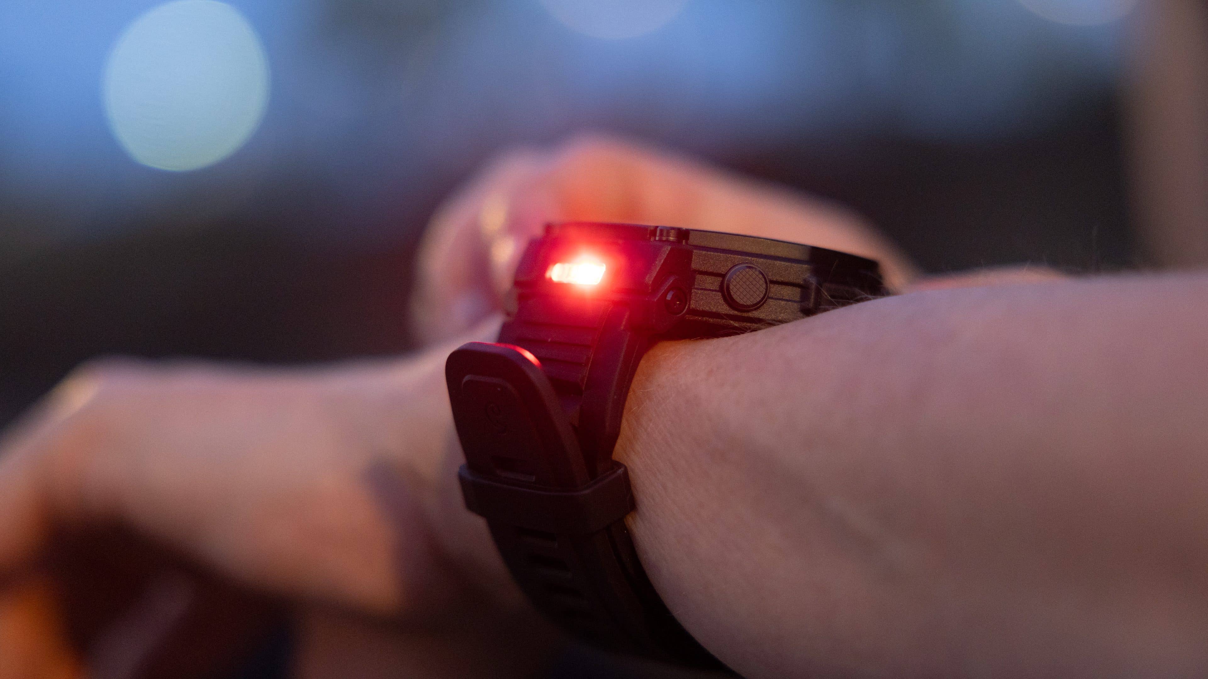 Eine Nahaufnahme einer Amazfit T-Rex Pro 3-Smartwatch, die ein rotes Licht am Handgelenk zeigt.