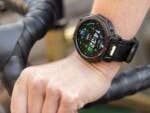 Eine Hand mit einer Amazfit T-Rex Pro 3-Smartwatch am Fahrradlenker, die Uhrzeit und Fitnessdaten anzeigt.