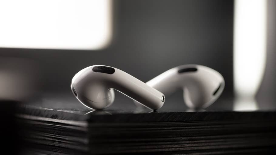 Nahaufnahme von Apple AirPods, die auf einer schwarzen Oberfläche liegen und ihr elegantes Design zeigen.