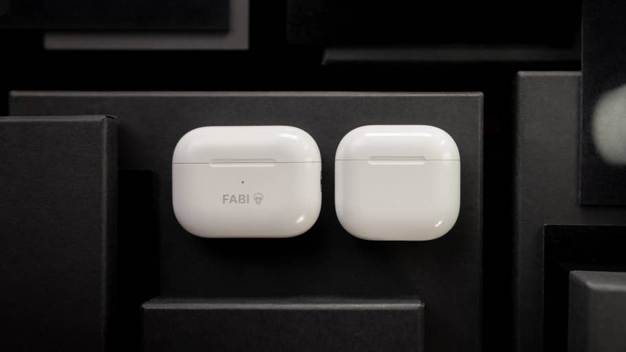 Weiße Apple AirPods-Hüllen auf dunklem Hintergrund, eine mit u0027FABIu0027-Text.