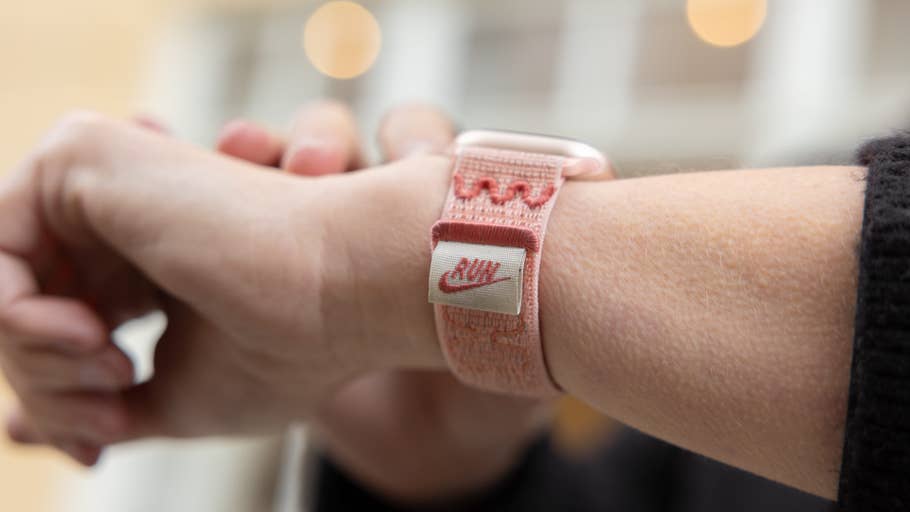 Eine Nahaufnahme eines Handgelenks mit einem pinken Nike Apple Watch Armband.