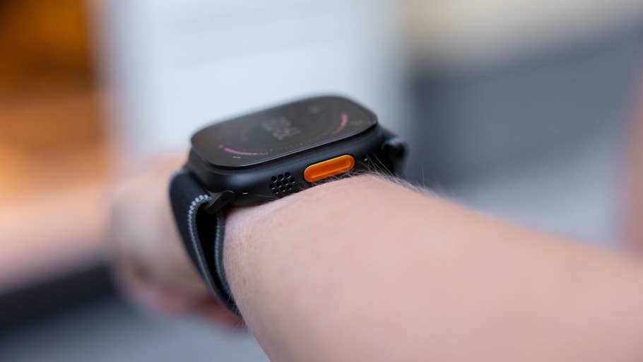 Nahaufnahme einer Apple Watch Series 3 Ultra am Handgelenk, die das Display und die orangefarbene Taste zeigt.