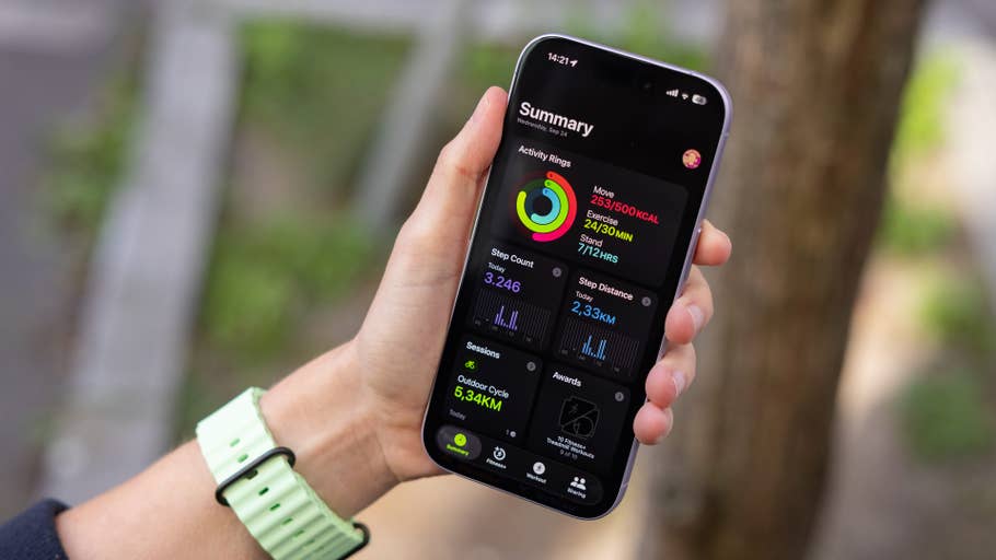 Eine Person hält ein Smartphone, das eine Aktivitätszusammenfassung von der Apple Watch zeigt.
