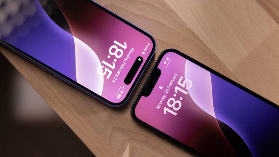 Zwei iPhones zeigen die Uhrzeit: 18:15 und 18:13 auf einer Holzoberfläche.