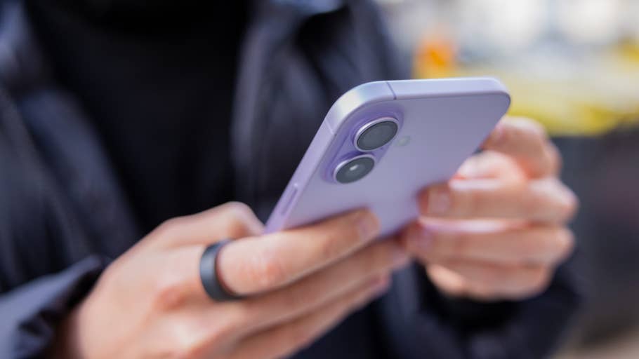 Eine Person hält ein Apple iPhone 17 in Lavendel, das sie mit beiden Händen benutzt.