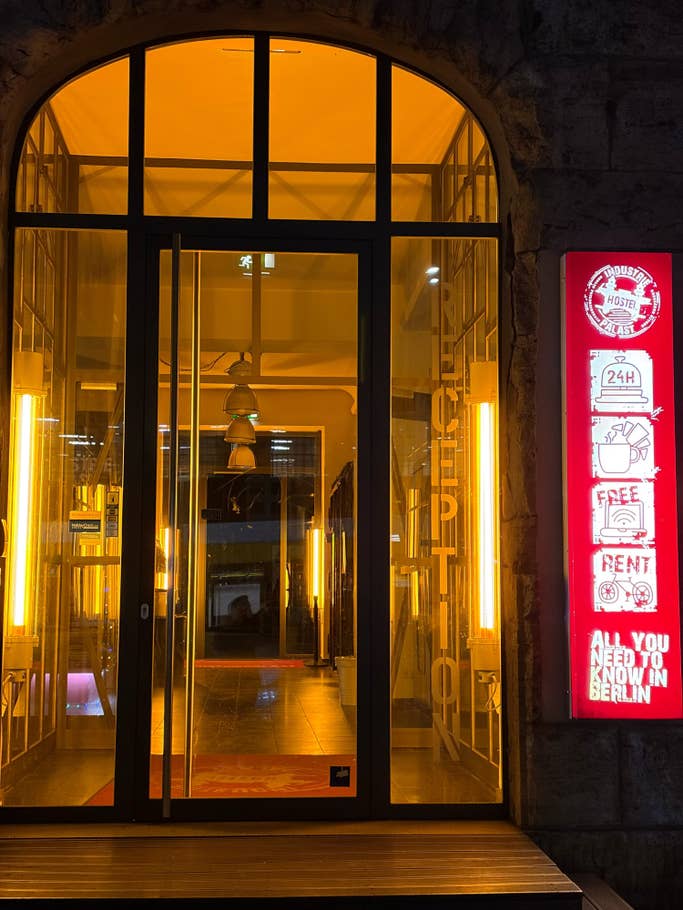 Eingang eines Hostels mit beleuchteten Schildern und einladender Atmosphäre.