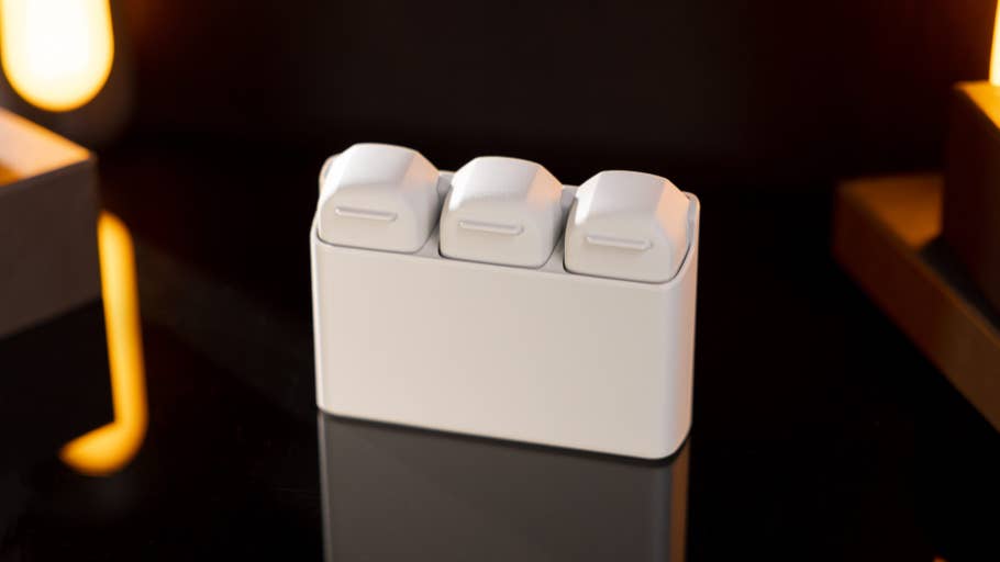 Ein kompaktes weißes Gerät mit drei Fächern, auf einer reflektierenden Oberfläche platziert.