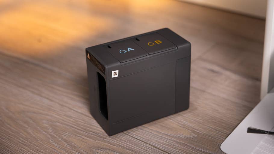 Dreame Aqua10 Ultra Roller, ein kompaktes schwarzes Gerät mit den Tasten A und B oben, auf einer Holzoberfläche platziert.