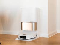 Ein Dreame X50 Ultra-Roboterstaubsauger, der an seiner Ladestation in einem modernen Innenraum angedockt ist.