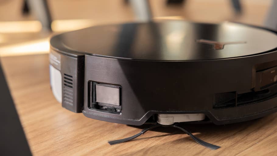 Nahaufnahme des Ecovacs Deebot X8 Pro Omni Staubsaugerroboters auf einem Holzboden.