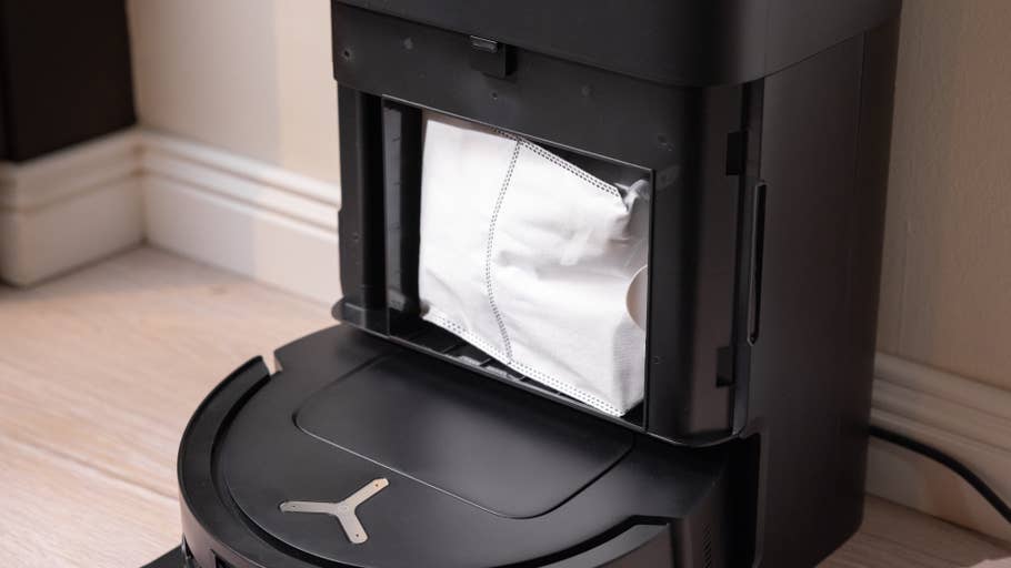 Nahaufnahme eines Ecovacs T80 Omni Staubsaugers mit einem offenen Fach, das einen Staubsack zeigt.