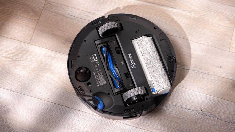 Unteransicht eines Ecovacs T80 Omni Saugroboters auf einem Holzboden.