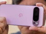 Eine Person hält ein Google Pixel 9 Pro-Smartphone, das seine rosa Rückseite und Kameraeinrichtung zeigt.
