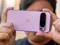 Eine Person hält ein Google Pixel 9 Pro-Smartphone, das seine rosa Rückseite und Kameraeinrichtung zeigt.