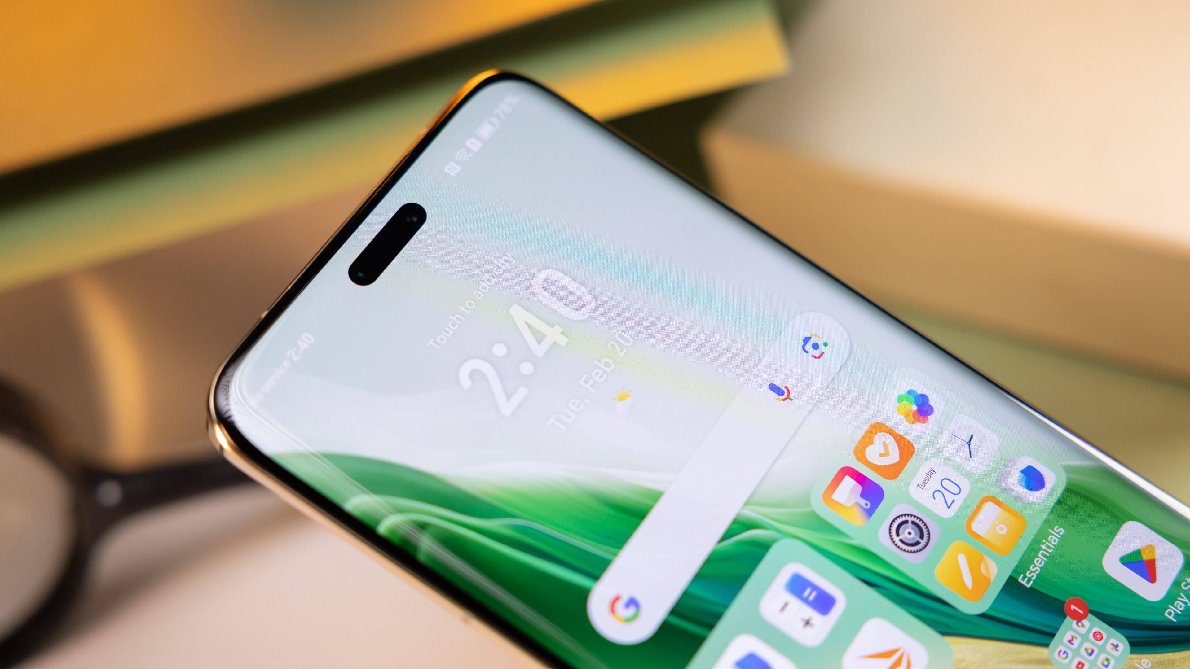 Dieses Bild zeigt die obere Vorderseite eines Smartphones und konzentriert sich auf das Display mit einer Lochkamera oben in der Mitte und einem leuchtend grünen Hintergrund.