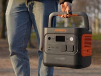 Eine Person hält einen Jackery Explorer 2000 tragbaren Stromgenerator im Freien.
