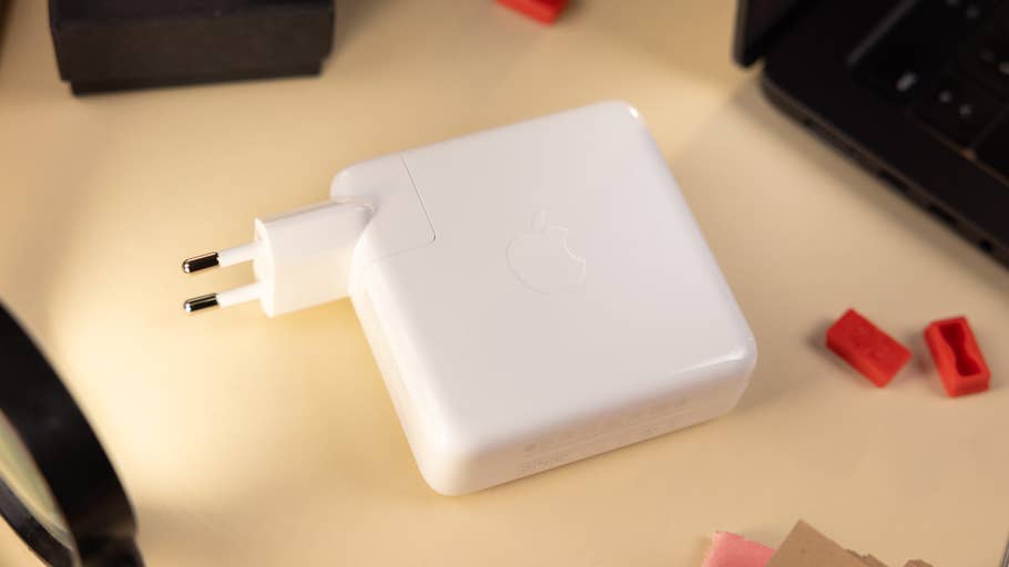 Mitgeliefertes Ladegerät des MacBook Pro mit 14 Zoll auf dem Tisch