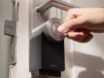 Eine Hand bedient ein Nuki-Smart-Lock an einer Tür.
