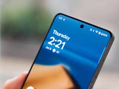Nahaufnahme eines Smartphones, das die Uhrzeit 2:21 und das Datum 9. Januar mit klarem blauen Hintergrund zeigt.