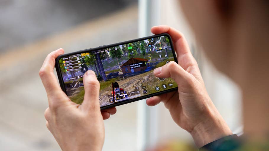 Eine Person, die ein mobiles Spiel auf einem Smartphone spielt.