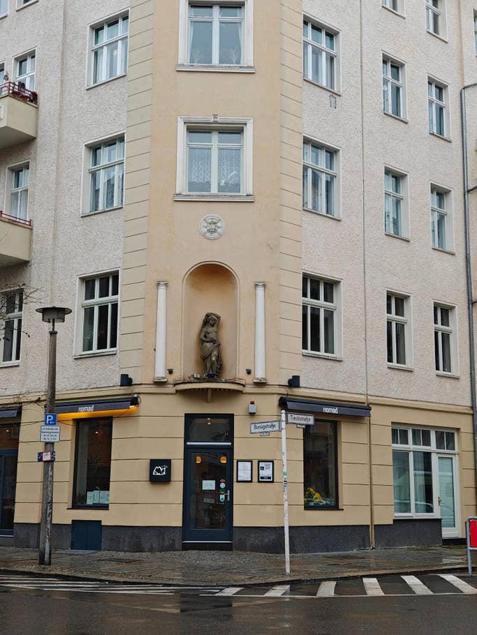 Eine Gebäudeecke mit einer verschnörkelten Statue.