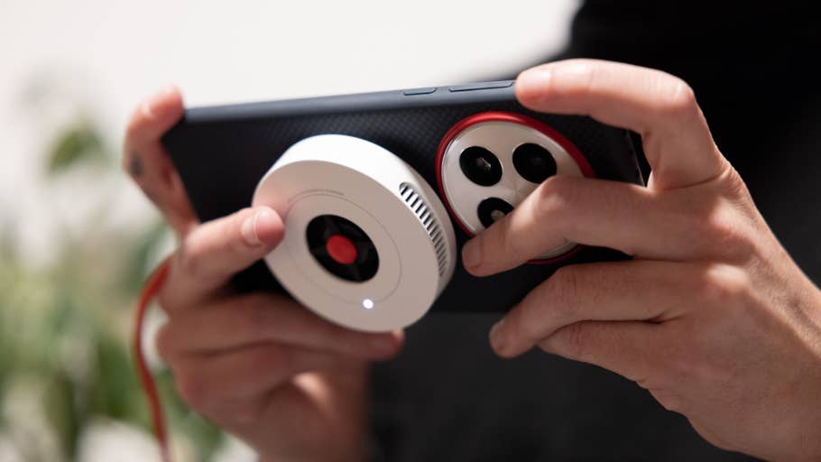 Eine Person hält ein OnePlus 13 Smartphone mit Kameraaufsatz.