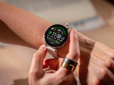 Eine Person überprüft die OnePlus Watch 3 an ihrem Handgelenk, die Uhrzeit und Fitnessdaten anzeigt.