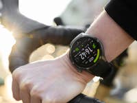 Eine Nahaufnahme eines Handgelenks mit einer OnePlus-Uhr, die einen Fahrradlenker hält und die Zeit und Metriken anzeigt.