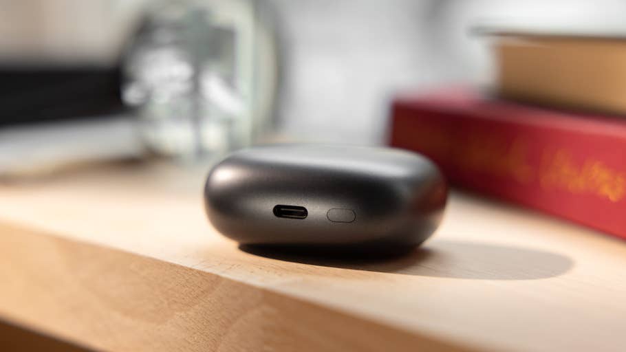 Nahaufnahme des schwarzen Redmi Buds 6 Pro Ladegehäuses auf einer Holzoberfläche.