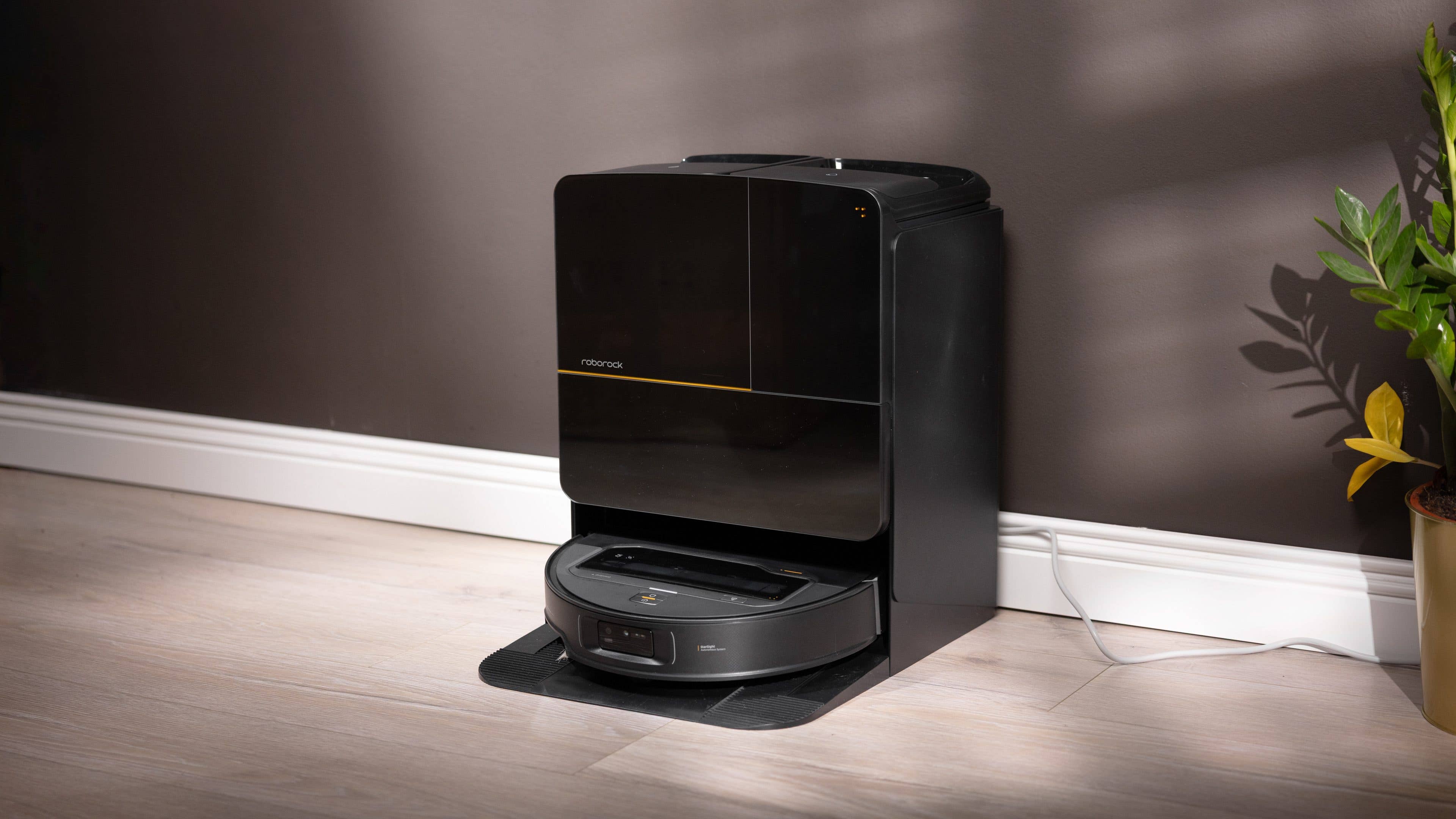 Ein schwarzer Roborock Saros Z70 Saugroboter, angedockt gegen eine Wand. Ein schwarzer Roborock Saros Z70 Saugroboter, angedockt gegen eine Wand.