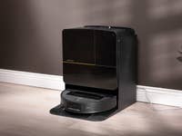 Ein schwarzer Roborock Saros Z70 Saugroboter, angedockt gegen eine Wand.