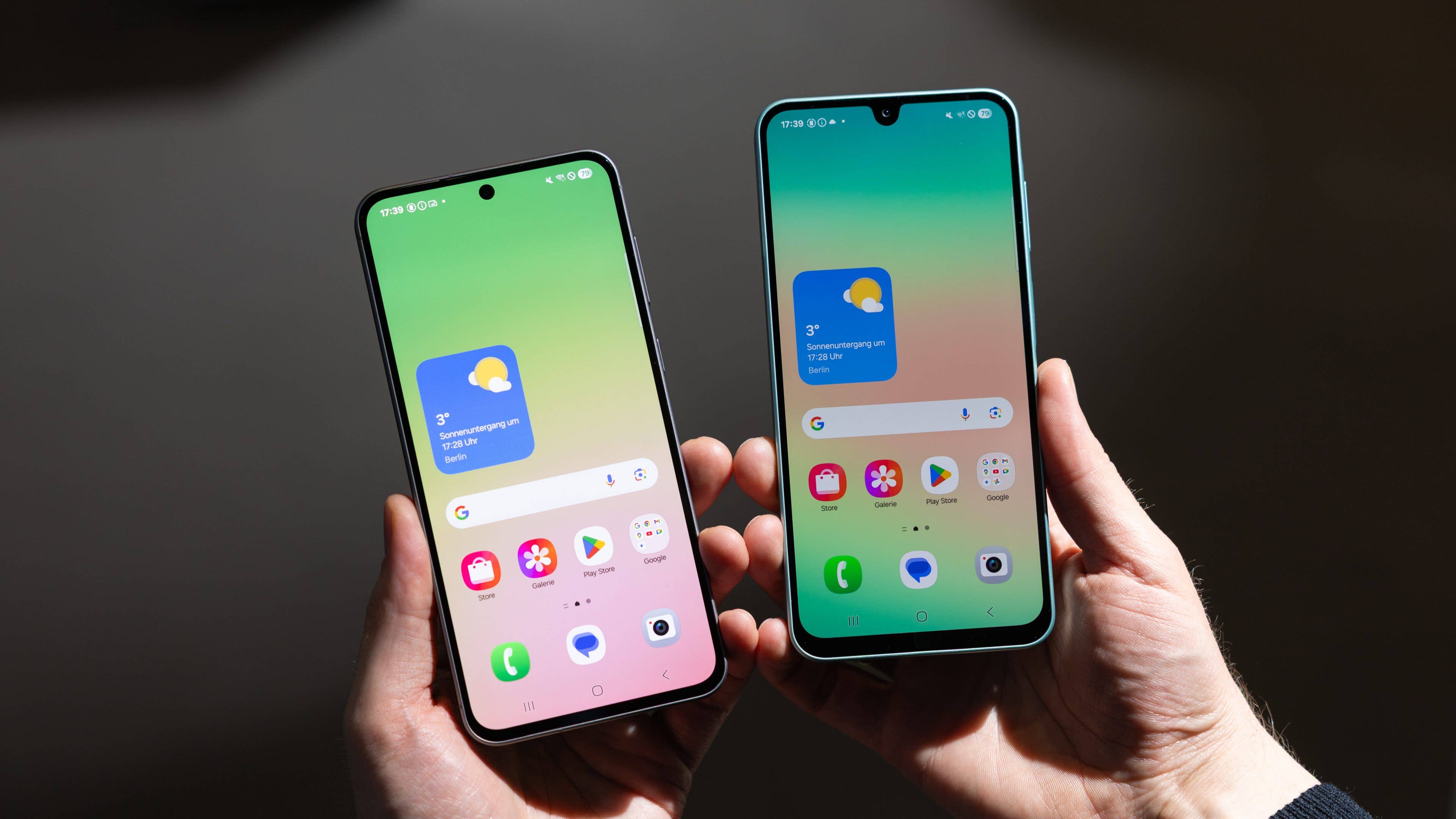 Zwei Samsung Galaxy A-Serie Smartphones in Händen, die bunte Bildschirme mit Wetterinformationen anzeigen.