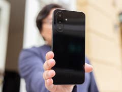 Eine Person hält ein Samsung Galaxy A26 Smartphone und zeigt die elegante schwarze Rückseite.