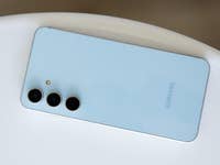 Samsung Galaxy S24 FE Smartphone mit drei Kameras auf der Rückseite, auf einer weißen Fläche platziert.