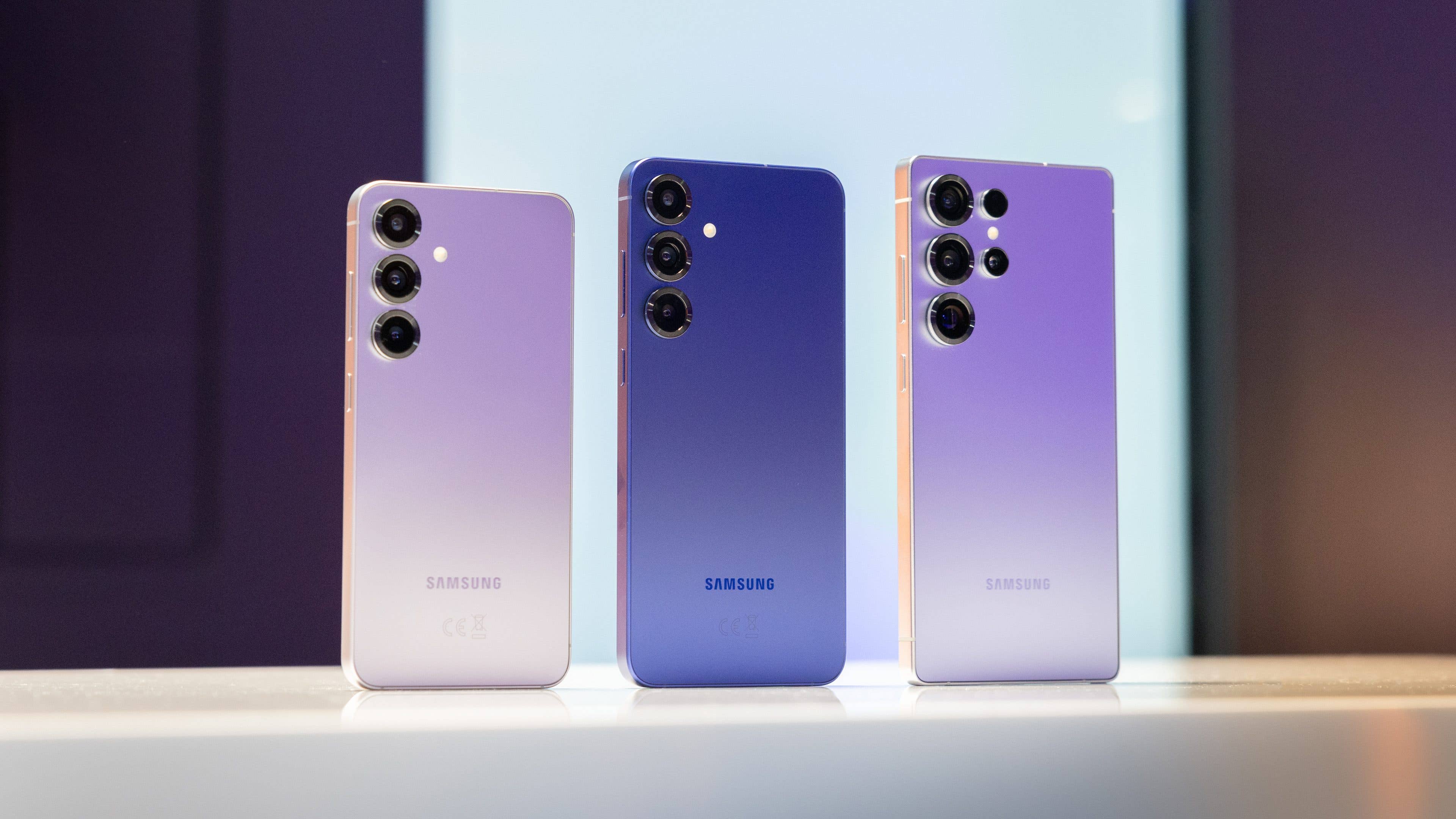 Drei Samsung Galaxy S25 Smartphones in Verlauffarben auf einem Tisch präsentiert.