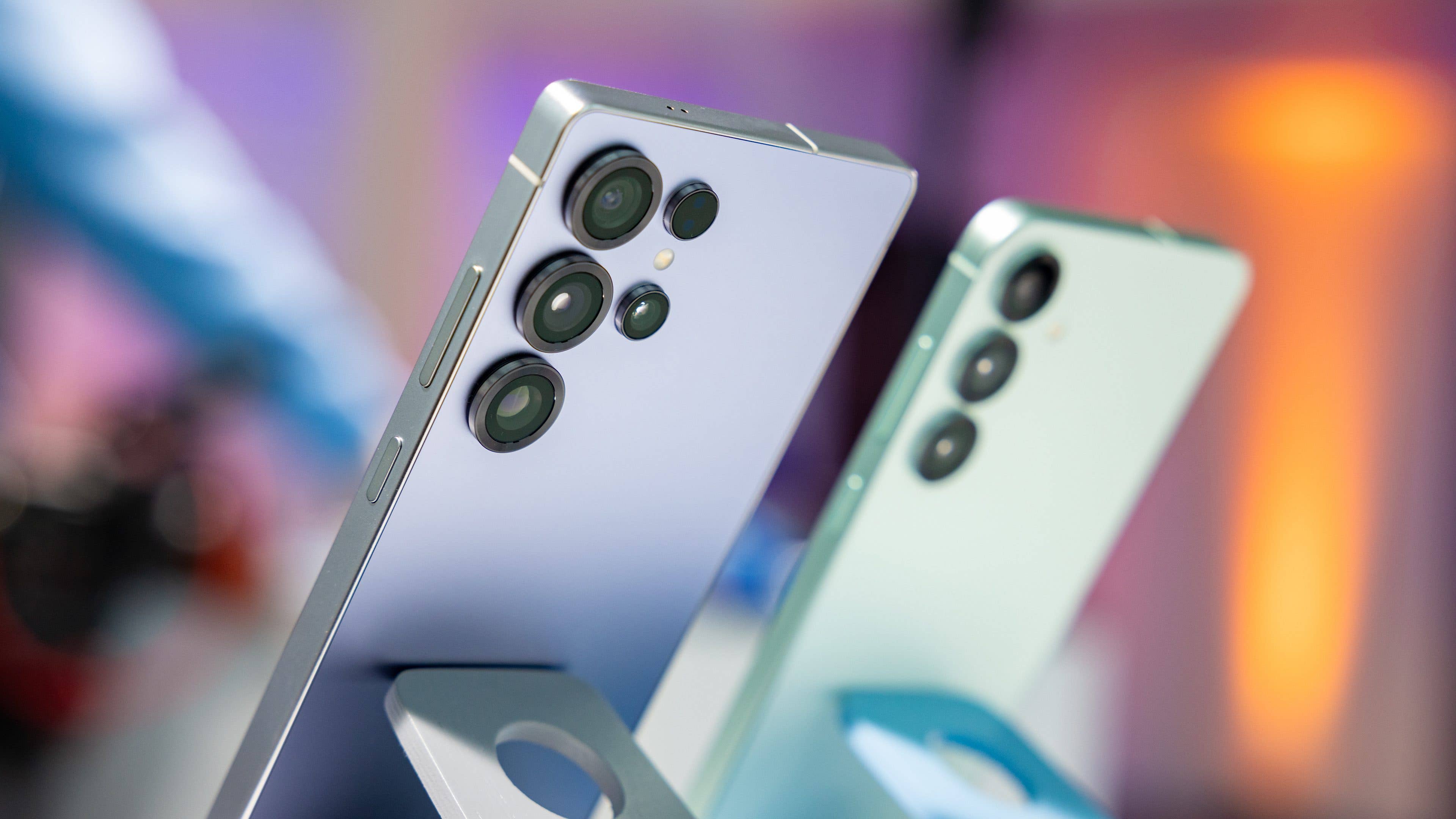 Zwei Samsung Galaxy S25 Smartphones, die in einem Winkel ausgestellt sind und ihre Kameras und schlankes Design zeigen.