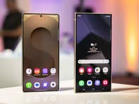 Zwei Samsung Galaxy S25 Smartphones werden auf einem Tisch mit lebhaften Hintergründen präsentiert.