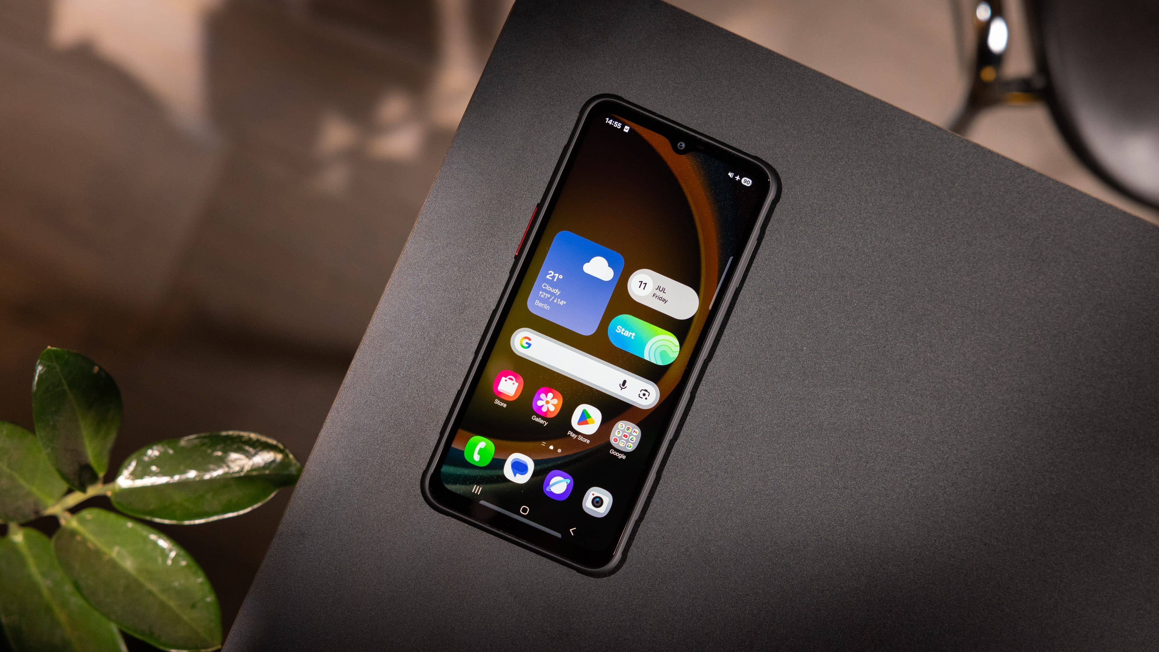 Samsung Galaxy XCover 7 Pro Smartphone auf einer schwarzen Oberfläche mit angezeigten App-Symbolen. Samsung Galaxy XCover 7 Pro Smartphone auf einer schwarzen Oberfläche mit angezeigten App-Symbolen.