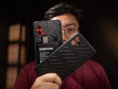 Eine Person hält ein Samsung Galaxy XCover 7 Pro Smartphone und seine Schutzhülle.