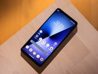 Sony Xperia 1 VIII Smartphone auf einer Holzoberfläche, zeigt den Startbildschirm mit Uhrzeit und App-Icons.