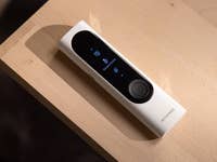 Ein Withings BeamO-Gerät auf einer Holzoberfläche, das ein Temperaturmessbildschirm zeigt.