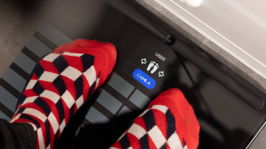 Füße in bunten Socken stehen auf dem Display einer Withings Body-Scan-Waage.