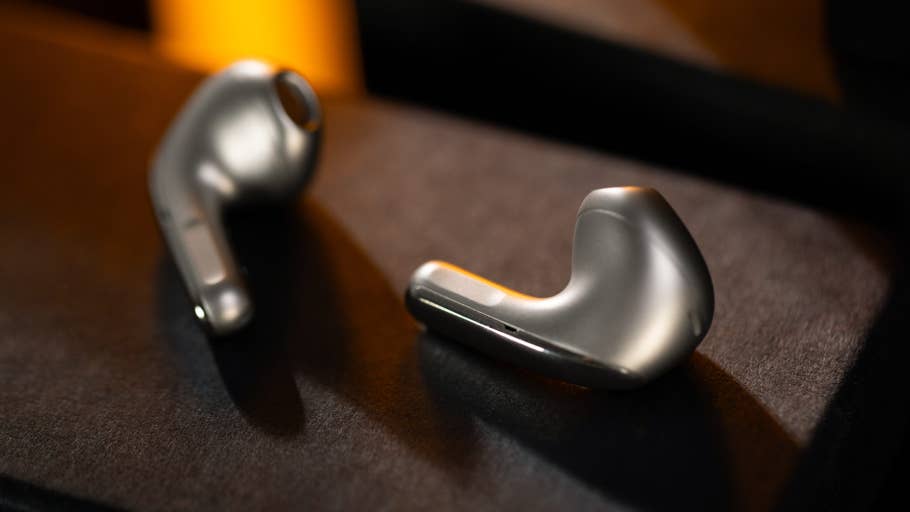Zwei Xiaomi Buds 5 kabellose Kopfhörer, die auf einer dunklen Oberfläche liegen.