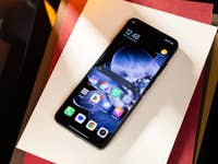 Xiaomi Mix Flip-Smartphone auf weißem Papier, das den Startbildschirm mit verschiedenen App-Symbolen zeigt.