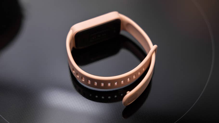 Xiaomi Smart Band 9 Active in sanftem Pink auf einer schwarzen Oberfläche.