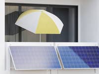 Balkon mit Sonnenschirm und zwei Solarpaneelen