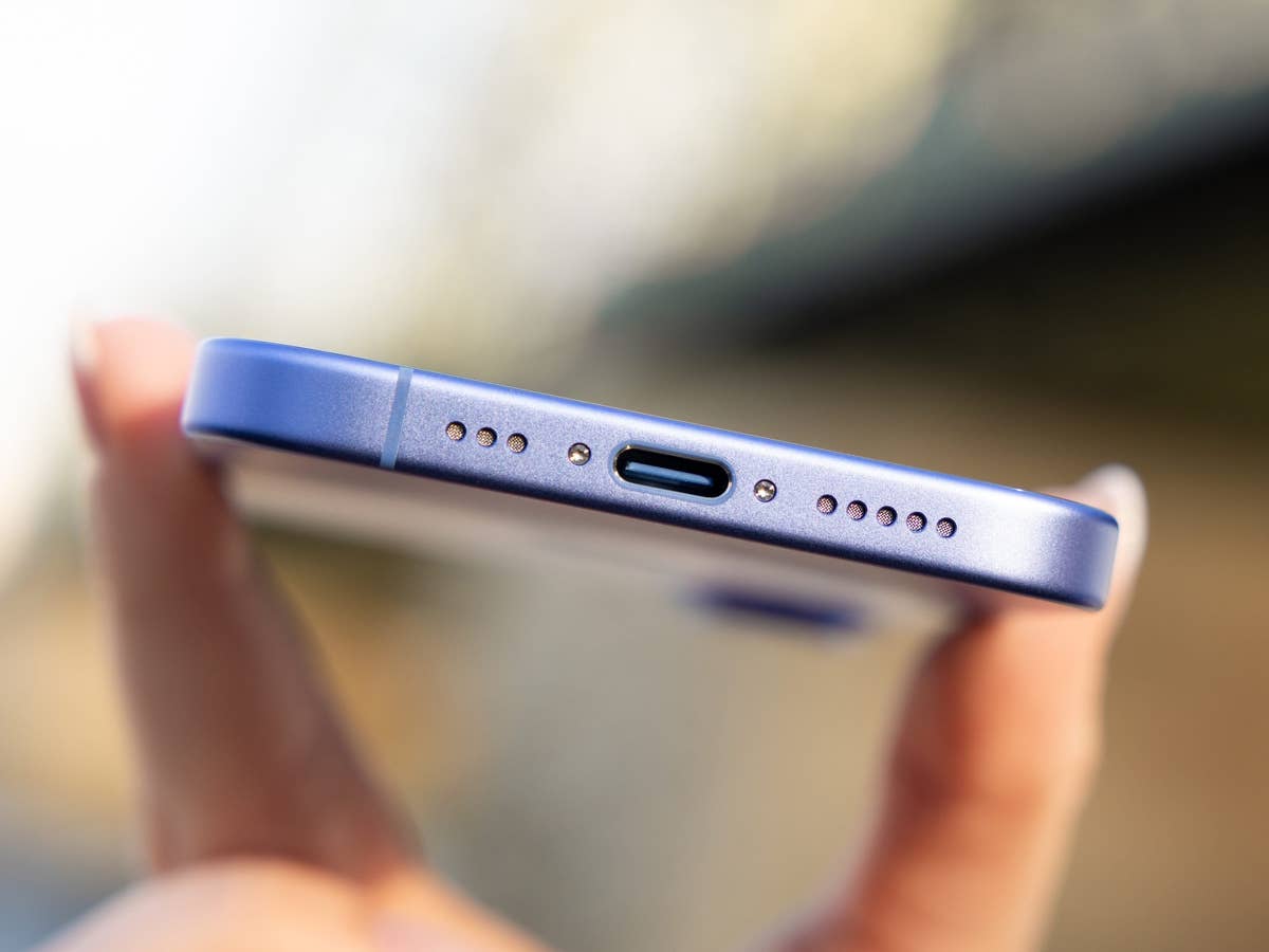 Nahaufnahme eines iPhone 16, das die Unterseite mit einem USB-C-Anschluss und Lautsprechern zeigt.