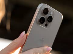 Eine Person hält ein iPhone 16 Pro und zeigt das Design mit der Triple-Kamera.